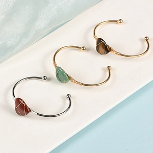 Luxurious gold and silver open bangles featuring handcrafted wire-wrapped natural crystals