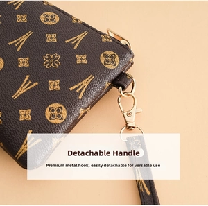 Detail of vintage monogram pouch with textured leather and gold-tone detachable wristlet strap