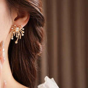 Detail of 18K gold-plated firework stud earring with pearls and zircon on model