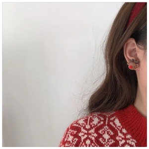 Close-up of a cute brown reindeer stud earring worn by a model for Christmas style
