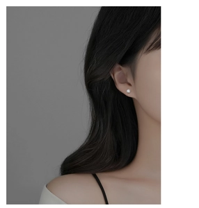 Close-up of S925 sterling silver ball stud earring with white zircon on ear