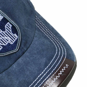 Detail of dark blue baseball cap showing contrast stitching and NY embroidery patch