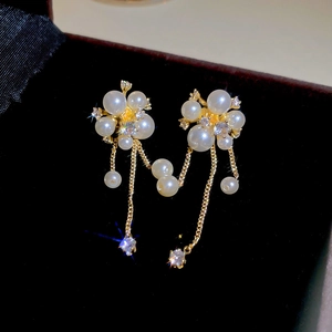 Macro shot of pearl flower tassel earrings with zircons in a black velvet jewelry box