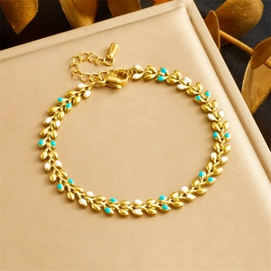 Detail of gold leaf chain bracelet with white and blue enamel in a luxury setting