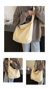 Detail of beige canvas tote bag showing wide shoulder strap and fabric texture