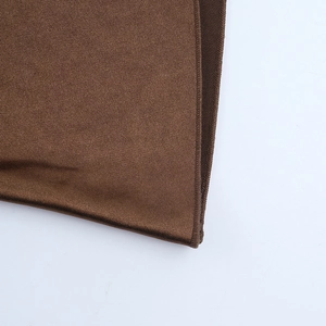 Detail of coffee brown satin fabric showing fine texture and precision overlock stitching