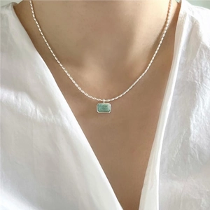 Close-up of 925 sterling silver beaded necklace with rectangular green stone pendant