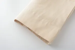 Close-up of beige twill jacket sleeve showing detailed horizontal stitching and fabric texture