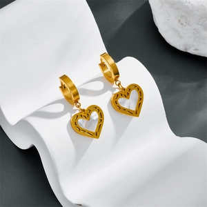 Macro detail of heart-shaped gold earring with white mother of pearl inlay on display