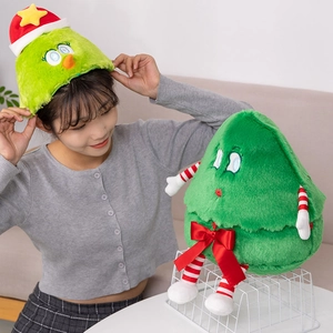 Detail of a green plush Christmas tree hat and doll with cute red bow ties and striped limbs