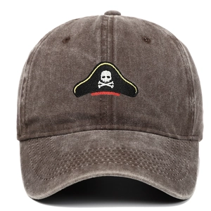Close-up of pirate skull embroidery on brown washed cotton distressed baseball cap