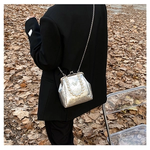 Detail of silver metallic crossbody bag with pearl handle and butterfly plaque