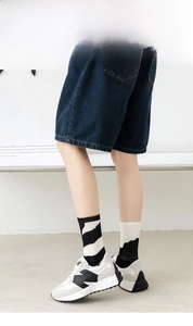 Detail shot of mid-calf knitted socks in black and white pattern with casual sneakers