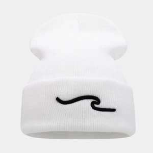 Détail du bonnet blanc à revers avec broderie vagues noires et texture en maille douce