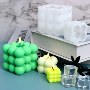 Macro detail of bubble cube silicone molds and finished handmade candles in soft colors