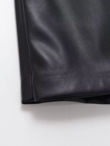 Primer plano de la textura de cuero PU negro y costuras finas en la minifalda con abertura
