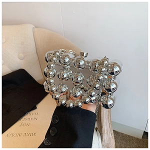Close-up of a high-shine silver spherical woven metal handbag for evening parties