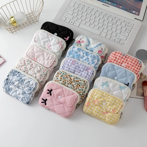 Flat lay of quilted mini storage pouches in floral and plaid patterns for earbuds