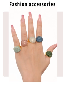 Detail of five colorful zircon paved rings on fingers in gold plated stainless steel