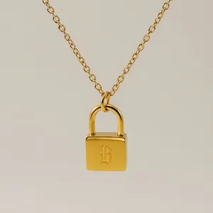Macro shot of gold padlock necklace pendant with elegant letter B engraving