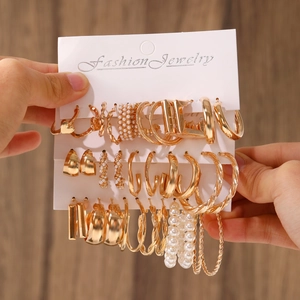 15-pair gold geometric earring set with pearls and hoops on a fashion jewelry card
