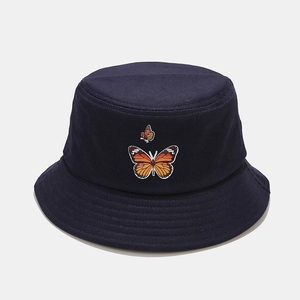 Détail de la broderie papillon sur le chapeau bob en toile de coton bleu foncé