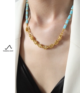 Close-up of gold stainless steel necklace with turquoise beads on model