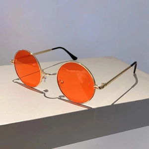 Détail de lunettes de soleil rondes vintage avec monture en métal doré et verres orange