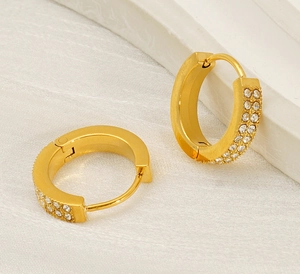Macro shot of gold hoop earrings with double row pavé zircons and a hinged closure