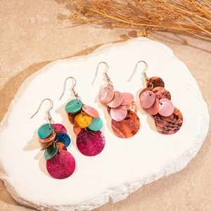 Boucles d'oreilles pendantes en nacre avec disques colorés sur plateau en pierre