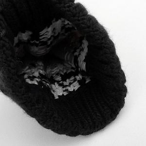 Macro detail of thick knit beanie lining showing premium black and white wool texture