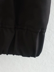 Close-up of elastic ribbed cuffs on a black casual bomber jacket with fine stitching