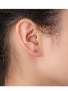 Close-up of minimalist silver twisted stud earring on female model ear for daily wear