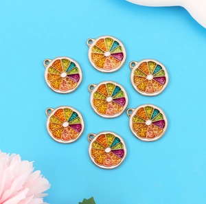 Close-up of seven colorful alloy fruit slice pendants on a blue background