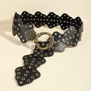 Dettaglio cintura a corsetto in pelle nera con occhielli dorati e fibbia barocca