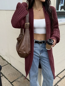Dettaglio del cardigan in maglia bordeaux che mostra la trama spessa e la vestibilità
