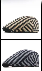 Detail view of striped beret caps in khaki and grey with adjustable metal side buckles