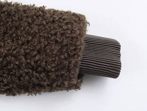 Detailed close-up of dark brown faux shearling fabric and ribbed knit texture