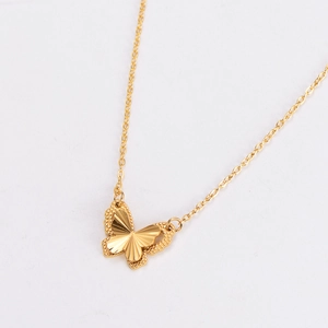 Detailed close-up of a gold-plated double-layered butterfly pendant with textured edges