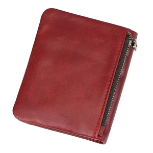 Macro shot of red grain leather wallet featuring vintage texture and metal zipper detail