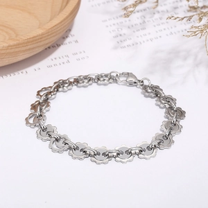 Macro view of silver gear-link bracelet with lobster clasp on a minimalist wooden tray