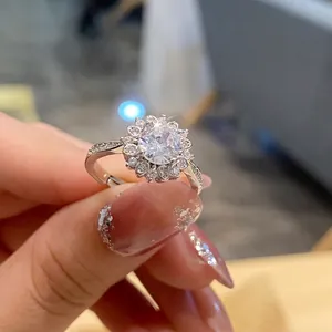 Close-up of sunflower shaped silver ring with sparkling round cut diamonds on a finger