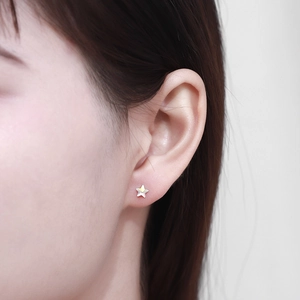 Macro detail of a 925 silver star earring with iridescent finish on person