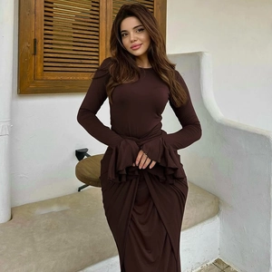 Détail d'une robe longue marron foncé élégante avec poignets plissés et ourlet drapé chic
