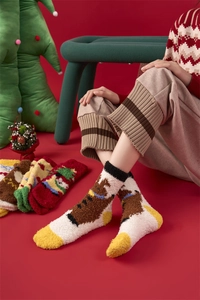 Detail of Christmas coral fleece socks with elk embroidery on model in festive red background