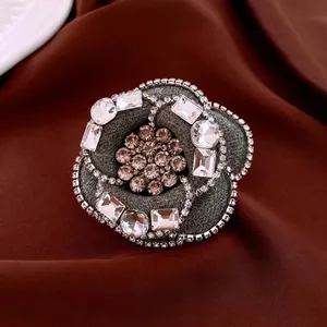 Luxury camellia brooch in grey tweed fabric with sparkling crystals and diamonds