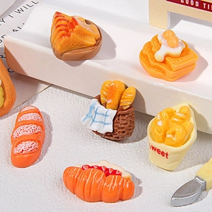 Macro shot of assorted miniature resin food charms including bread and hot dogs for DIY crafts