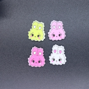 Four colorful resin bunny charms for DIY phone cases on a matte black background