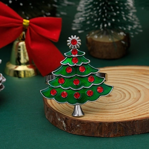 Macro detail of a green enamel Christmas tree napkin ring with sparkling red rhinestones