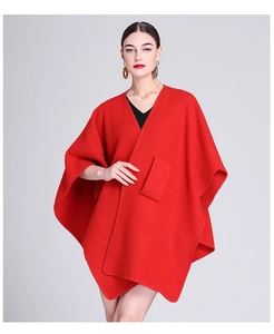 Detailed front view of red V-neck knit poncho cape with functional front pocket